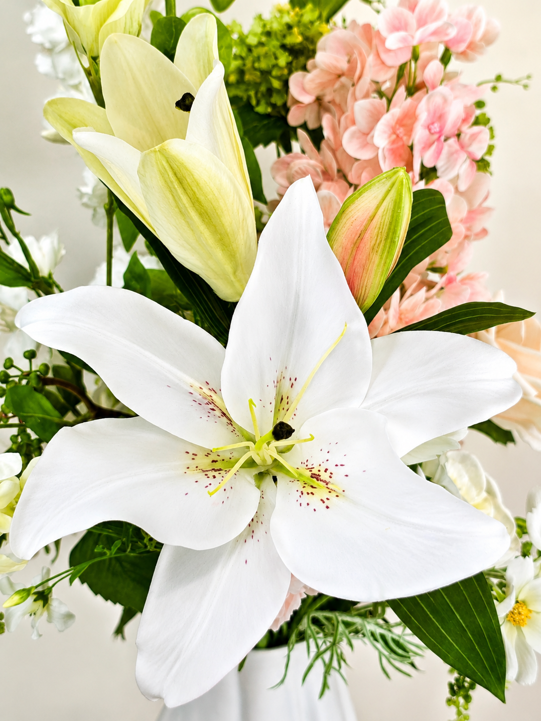 Zijden boeket Hannah met zachte roze en witte bloemen in witte vaas van Fleurisant