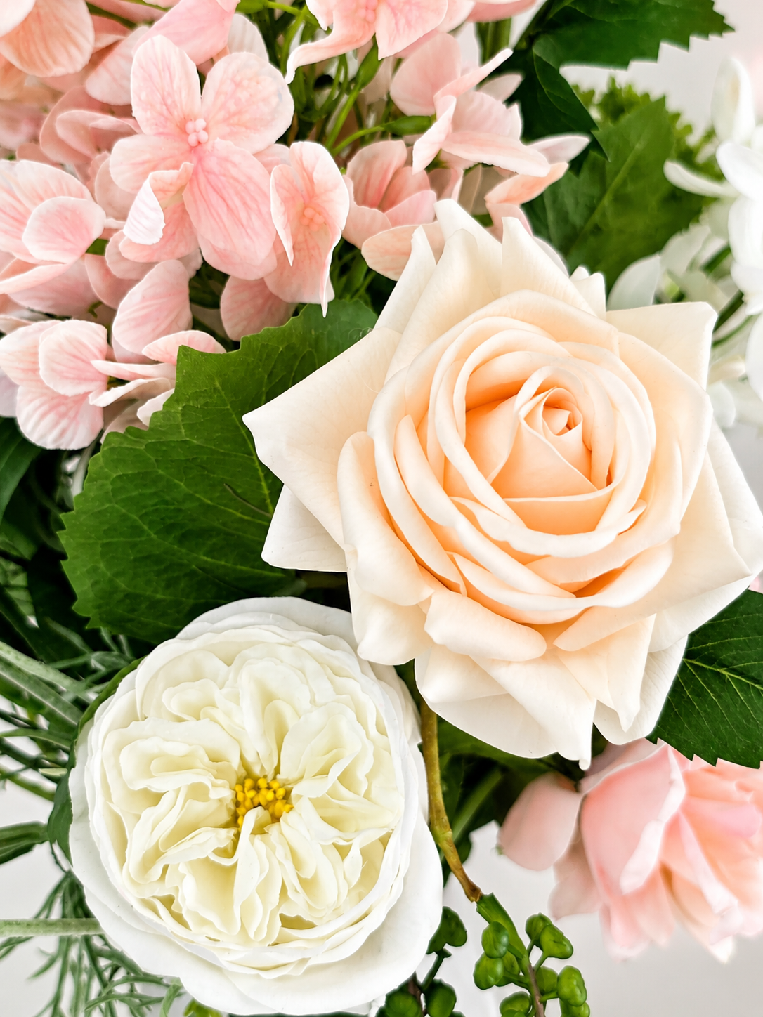 Zijden boeket Hannah met zachte roze en witte bloemen in witte vaas van Fleurisant